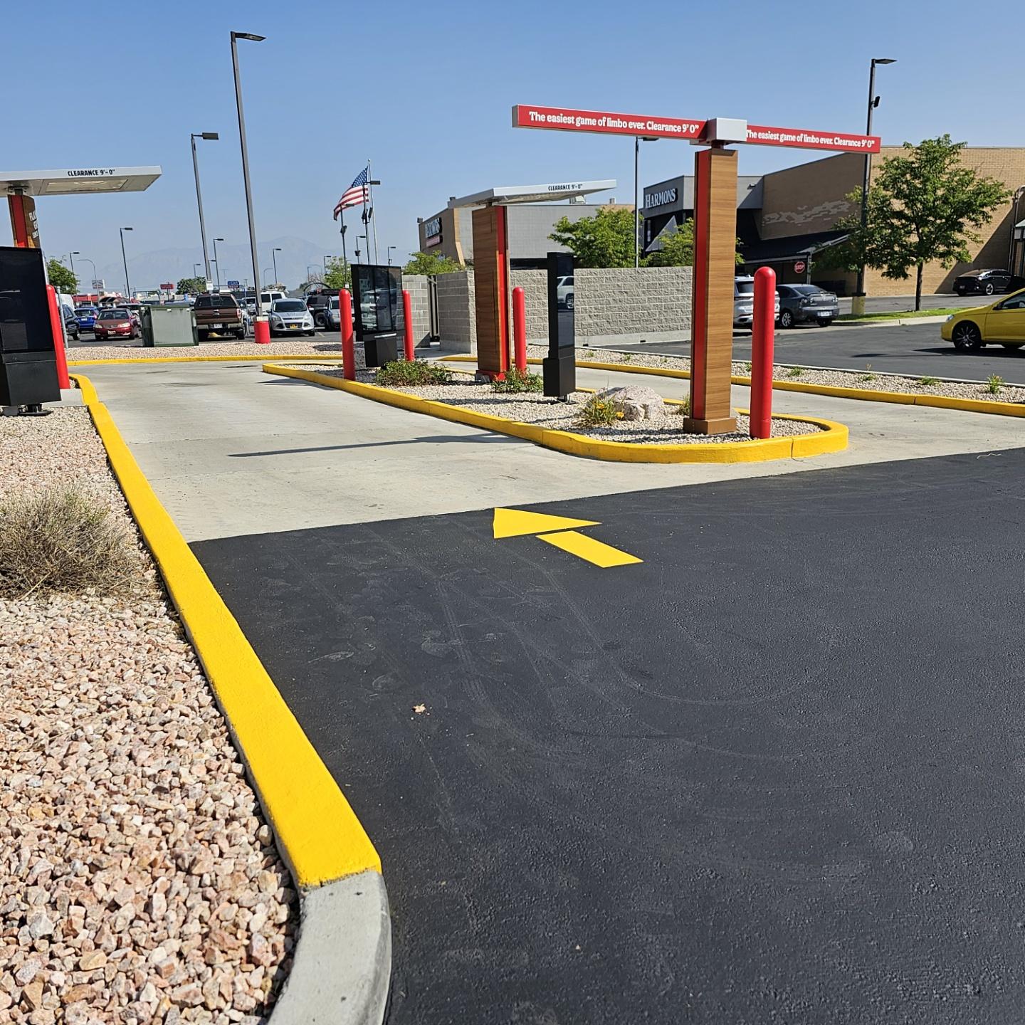 Freshly painted yellow curb and directional arrow at a drive-thru