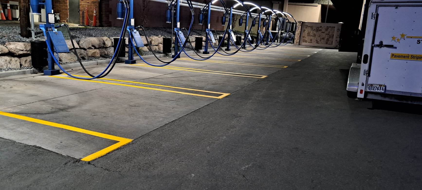 Crisp yellow striping at a car wash bay at night